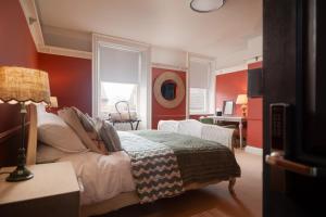 a bedroom with red walls and a bed and a desk at 35 Kirkgate in Thirsk
