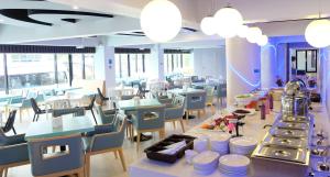 a restaurant with blue tables and chairs and a cafeteria at Sunny Residence in Lat Krabang