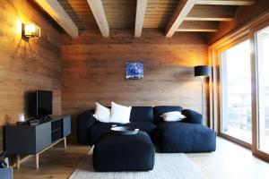 a living room with a blue couch and a television at Plünggas Chalets in Gaschurn