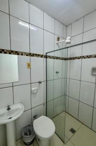 a bathroom with a toilet and a sink at Hotel Caiçara Matão in Matão