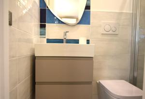 a bathroom with a sink and a toilet and a mirror at Appartamento Dea in Marina di Campo