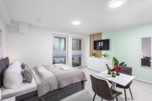 a bedroom with a bed and a table and a room with a bed at BrockHeus Riverside Aparthotel Magdeburg in Magdeburg