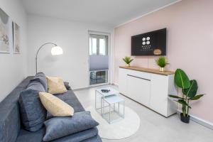a living room with a blue couch and a table at BrockHeus Riverside Aparthotel Magdeburg in Magdeburg