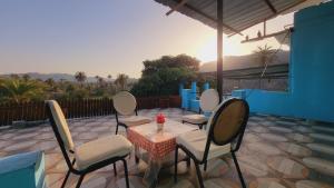 a patio with four chairs and a table and a table and chairs at Rudrakshi Inn in Mount Ābu