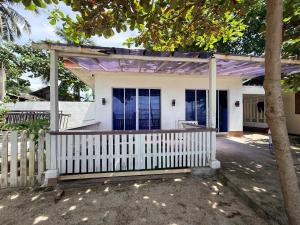 a house with a white fence and a tree at DJL Beach House - Bantayan Island in Patao +10 photos
