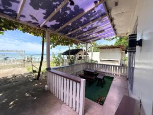 a porch with a picnic table and a view of the ocean at DJL Beach House - Bantayan Island in Patao