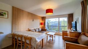 a living room with a table and a couch at Residence les Pleiades in Flaine