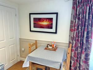 a table and chair in a room with a picture on the wall at Little Nauvoo in Bath