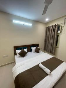 a bedroom with a large bed with white sheets and pillows at Cozy Inn Hotel in Noida