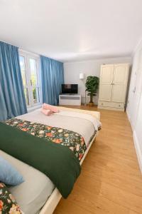 a bedroom with a large bed with blue curtains at Spacious Double Room in Shared Flat in Sutton