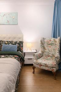 a bedroom with a bed and a chair and a lamp at Spacious Double Room in Shared Flat in Sutton +2 photos