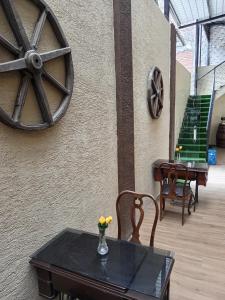 a table and chairs with a wheel on the side of a wall at Hotel Gavilu in Ambato