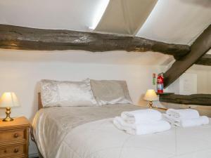 a bedroom with a bed with towels on it at Cottage 2 in Keswick