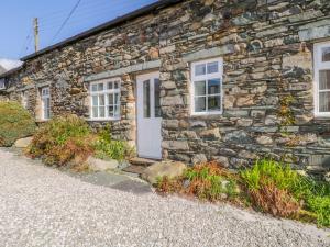 a stone cottage with a white door and windows at Cottage 2 in Keswick +4 photos