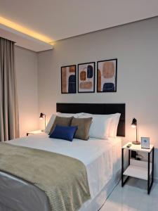 a bedroom with a large white bed and two lamps at Studios Leme 11 - conforto para casal - com varanda in Espirito Santo Do Pinhal