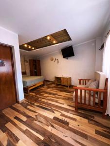 a living room with a wooden floor and a bed at Casa Nuna in Tilcara +23 photos