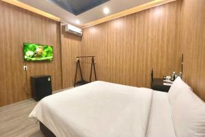 a bedroom with a bed and a tv on a wall at Lion Homestay Huế in Thôn Lại Thê