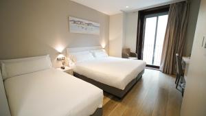 a hotel room with two beds and a window at Hotel Centre Reus in Reus +68 photos