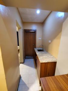 a small kitchen with a sink and a door at Romeo Apartment in Ipaja +42 photos