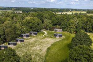 an aerial view of a farm with buildings on a grass field at Ecopark Twente Cabin Tilligte in Tilligte