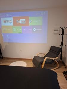 a room with a projection screen and two chairs at Secret Night in Audincourt