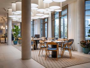 a dining room with tables and chairs and windows at ScanHotels Stadthafen in Rostock +93 photos