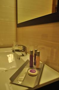 a bathroom sink with two bottles of cosmetics on a tray at Hotel Solineu in La Molina
