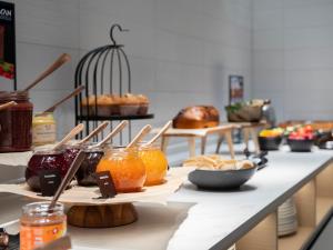 a counter with jars of jam and other food on it at ScanHotels Stadthafen in Rostock