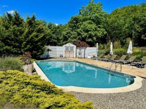 a swimming pool in a yard with chairs and a house at Domaine De JI in Montagnac