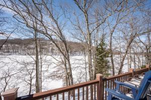 two blue chairs sitting on a wooden deck with snow at Corks Away by Railey Vacations in McHenry