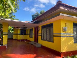 a yellow house with a red door at Shans Villa in Trincomalee