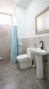 a bathroom with a white toilet and a sink at Apto cerca a Paseo Colon in Puerto La Cruz