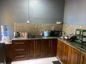 a kitchen with wooden cabinets and a counter top at Shans Villa in Trincomalee