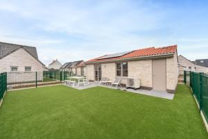 an image of a backyard with green grass at Duinhuis 20 P in Oostduinkerke