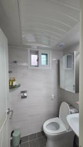a white bathroom with a toilet and a sink at La Petite Maison d'Hôtes in Seoul +16 photos