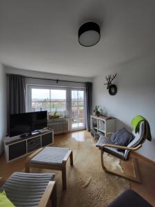 a living room with a couch and a tv at Ferienwohnung Kraichgaublick in Angelbachtal