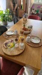 a wooden table with two plates of food on it at Chambre confortable chez Isabelle in Cléden-Cap-Sizun