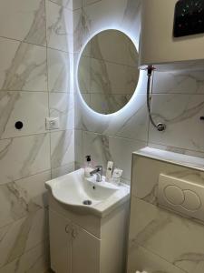 a white bathroom with a sink and a mirror at Happy moments Studio Kraljevo in Kraljevo