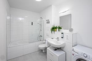 a white bathroom with a sink toilet and a shower at BrockHeus Riverside Aparthotel Magdeburg in Magdeburg