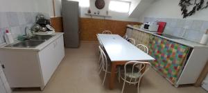 a kitchen with a table and chairs in it at Páterdombi Vendégház in Zalaegerszeg