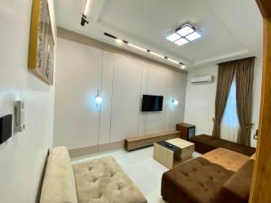 a living room with a couch and a tv at Ghomes in Lagos
