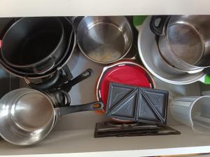 a bunch of pots and pans on a shelf at Charming guest suite in triborder area in Huningue +15 photos