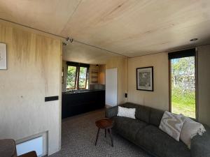 a living room with a couch and some windows at Tinyhouse Polderpanorama in Haastrecht