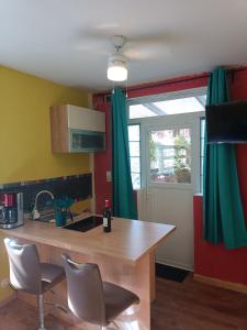 a kitchen with green curtains and a table and chairs at Charming guest suite in triborder area in Huningue