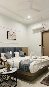 a bedroom with a large bed and a table at Hotel Leaf inn in Ahmedabad
