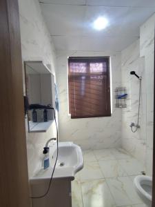 a white bathroom with a sink and a window at Yörük konaklama in Burdur