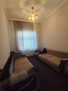 a room with three beds and a window with a chandelier at Yörük konaklama in Burdur