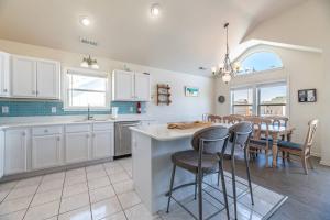 a kitchen with white cabinets and a table with chairs at On The Beach - Kitty Hawk, MP 1, Less than 50 Yards to Beach, Ocean View, Pool, Hot Tub, Pets OK in Kitty Hawk