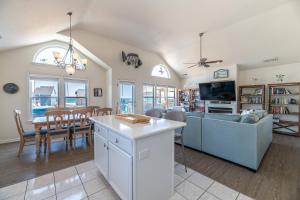 a living room with a couch and a table at On The Beach - Kitty Hawk, MP 1, Less than 50 Yards to Beach, Ocean View, Pool, Hot Tub, Pets OK in Kitty Hawk +33 photos
