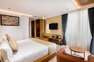 a hotel room with a bed and a television at AIRA Boutique Hotel in Bangalore
